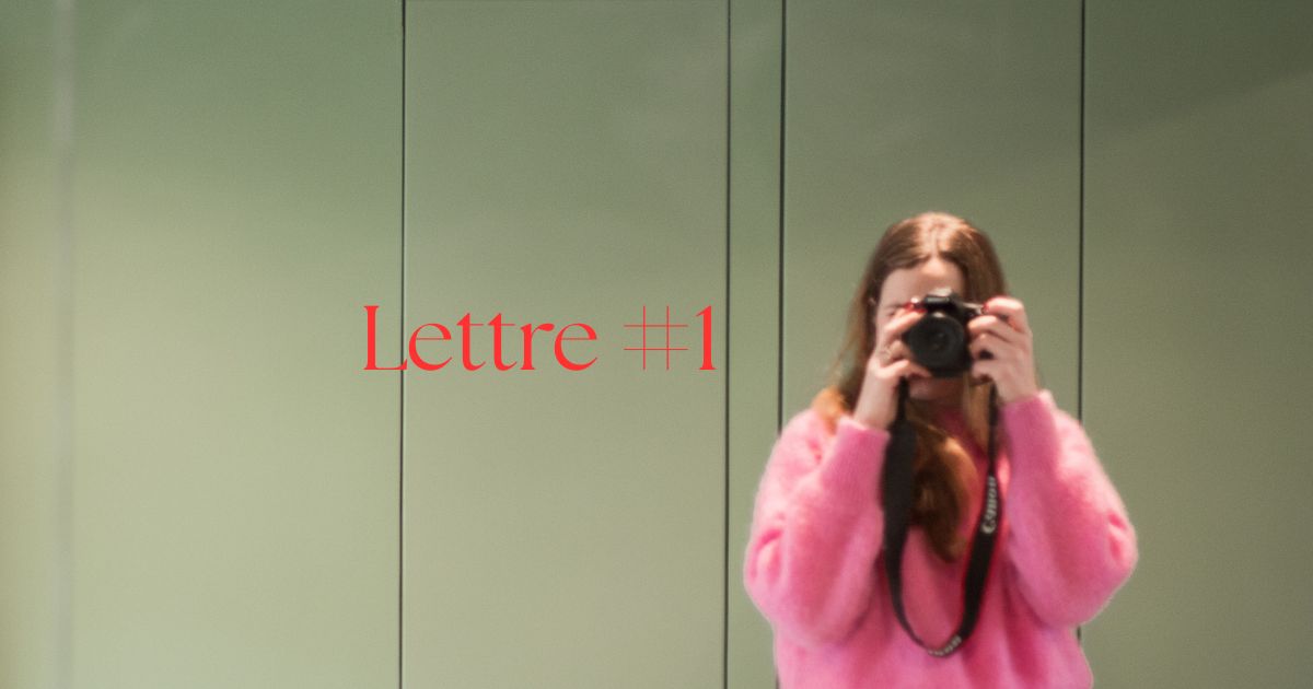 jeune femme cheveux longs pull rose prend un auto-portrait dans un miroir, le fond est vert