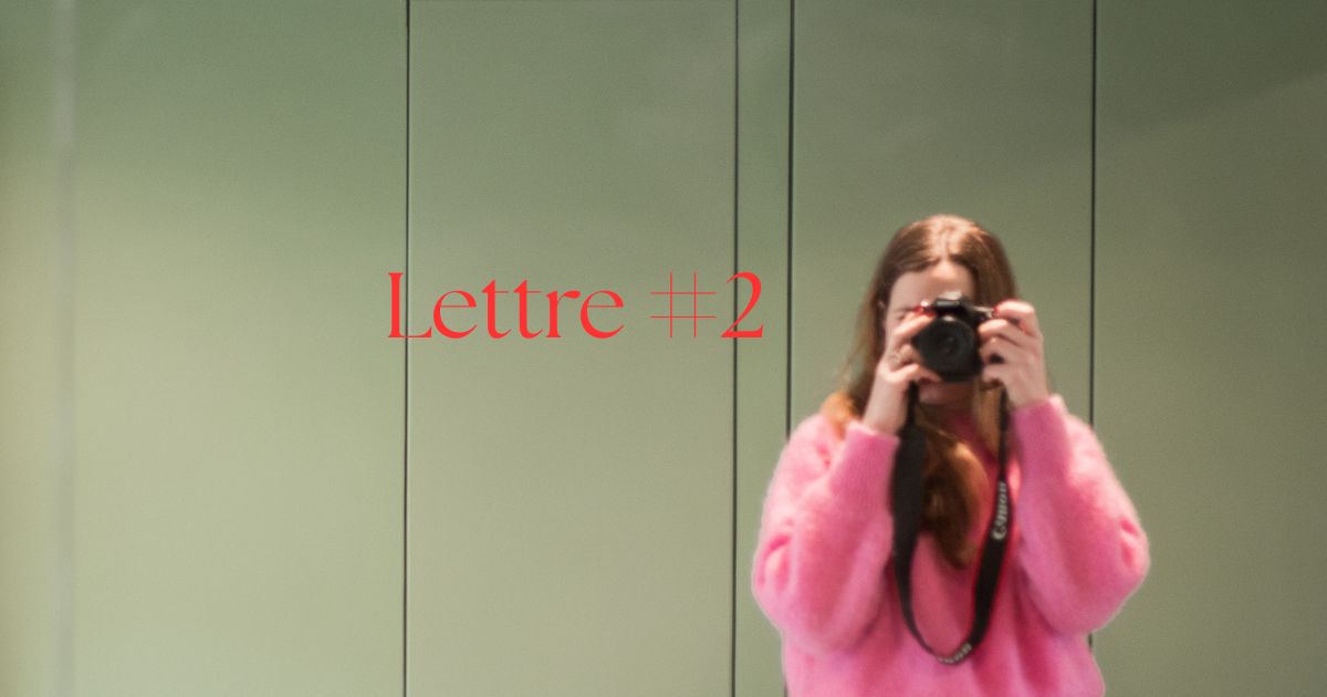 jeune femme blonde avec un pull rose prend une photo d'elle meme dans un miroir